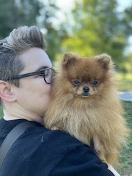 A woman holds a Pomeranian