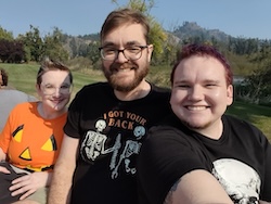 Two men and a woman smile at the camera