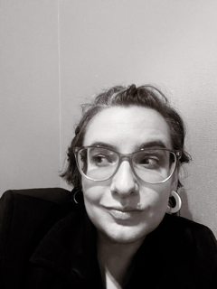 A black and white image of woman in glasses looking off to the side