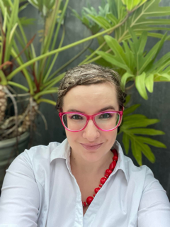 A woman sits in front of plants