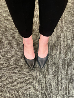 Legs in black pants with one blue and one black shoe